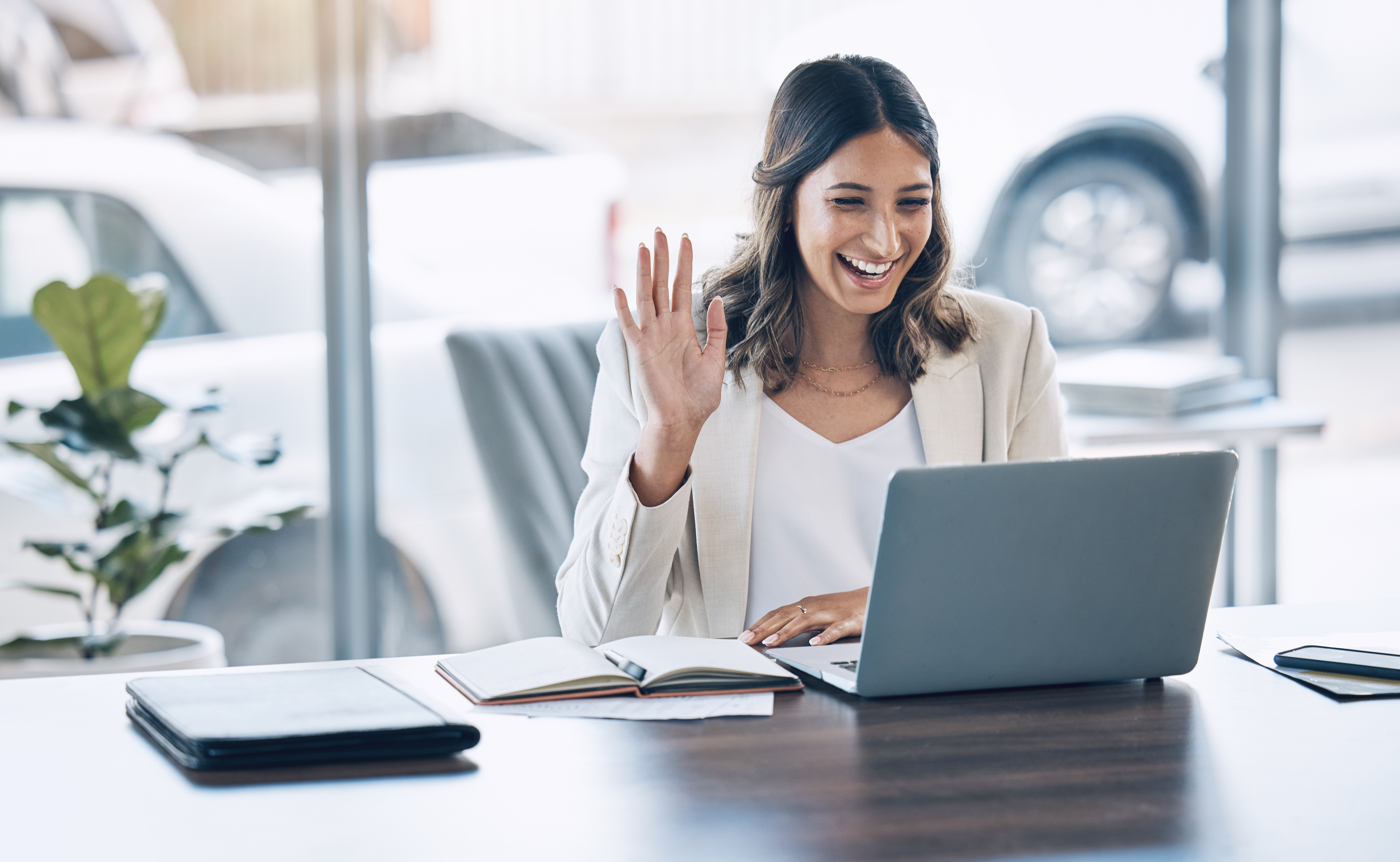 student learning virtually waving at people on video call