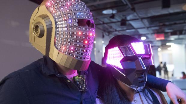 two students wearing funky helmets