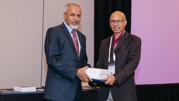 Sreenivasan standing with Dr. Muhammed Taher Saif, holding prize