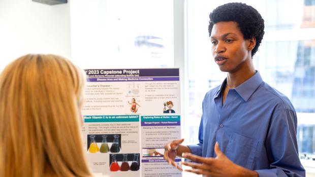 student presenting research poster