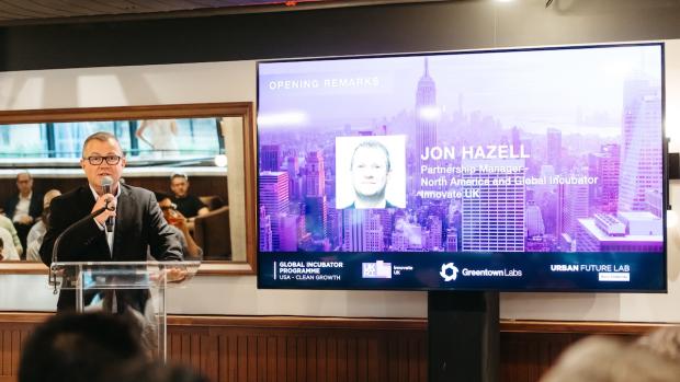 man speaking at podium in front of presentation