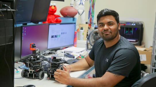 student with robots in the lab