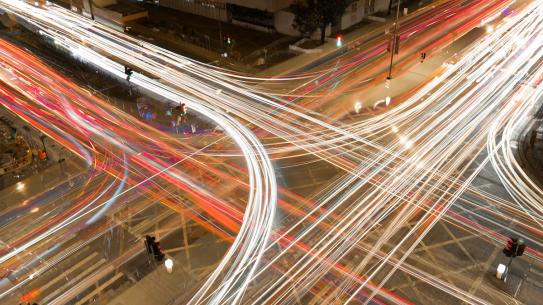 cars crossing intersection at night