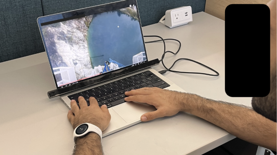 Man looking at computer with a smartwatch on.