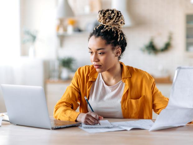 Person with yellow shirts studying in front of a computer