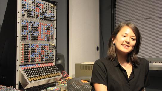 student in front of sound board