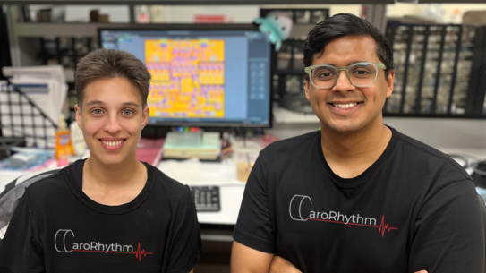 Two smiling graduate students wearing team shirts