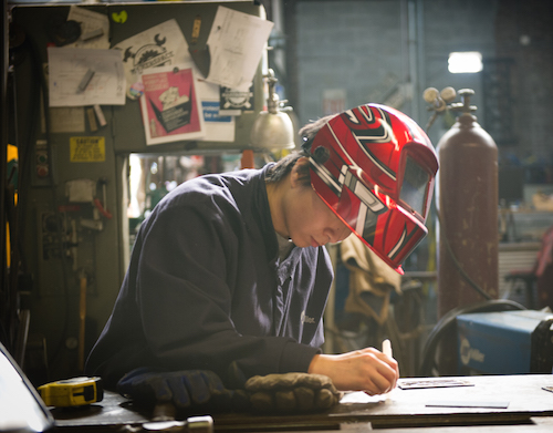 Student preparing steel for welding